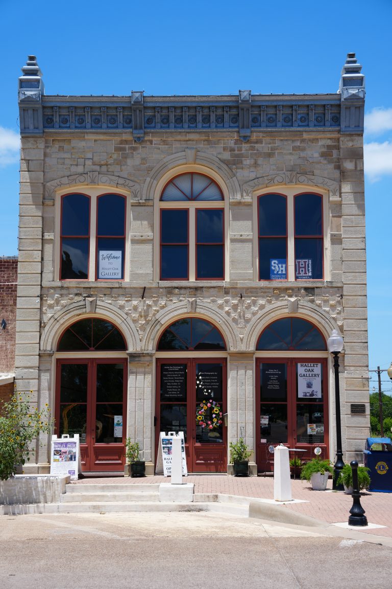 Stone-fronted building at 115 N Main with Hallet Oak Gallery signs in the windows